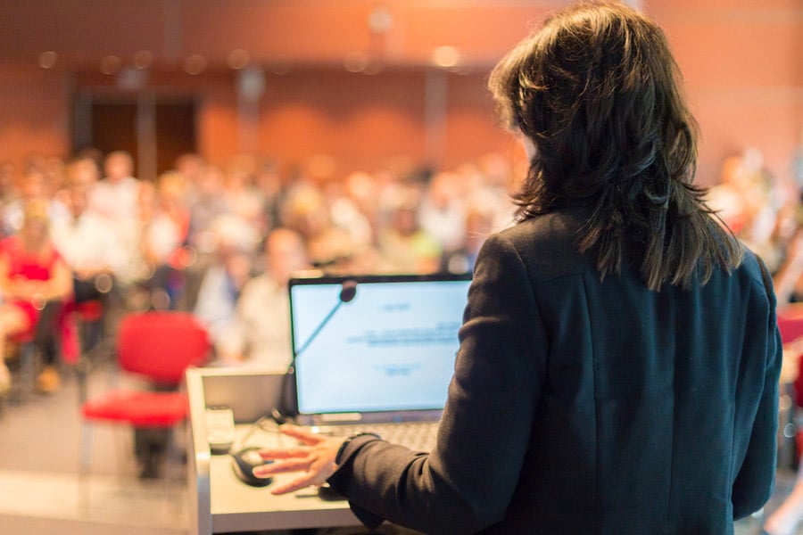 Conférencier au podium présentant à un auditoire